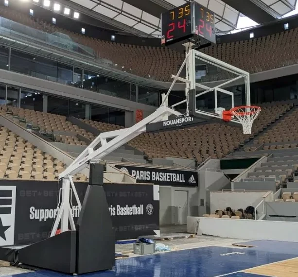 Cette image est une photographie d'un but de basket intérieur. Elle illustre l'ensemble des équipements de basket intérieur que Nathis peut fournir et installer pour les collectivités de Bretagne.