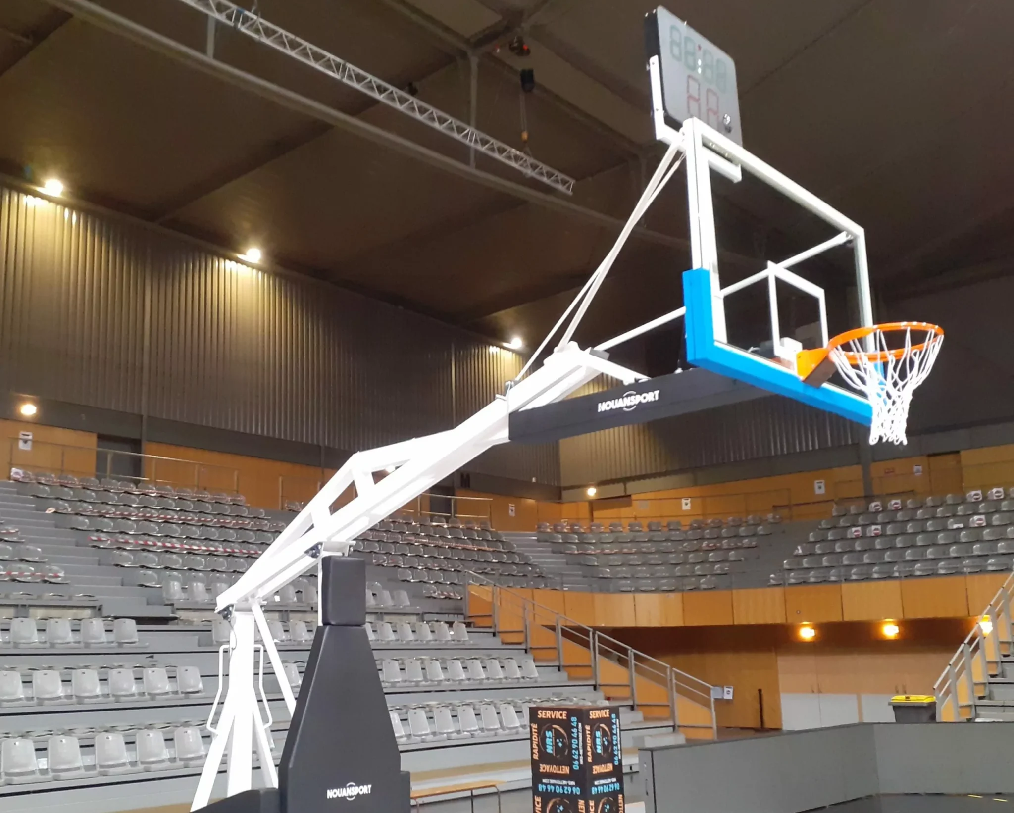 Cette image est une photographie d'un but de basket intérieur illustrant les équipements sportifs de basket que Nathis peut fournir et installer pour les collectivités partout en Bretagne.