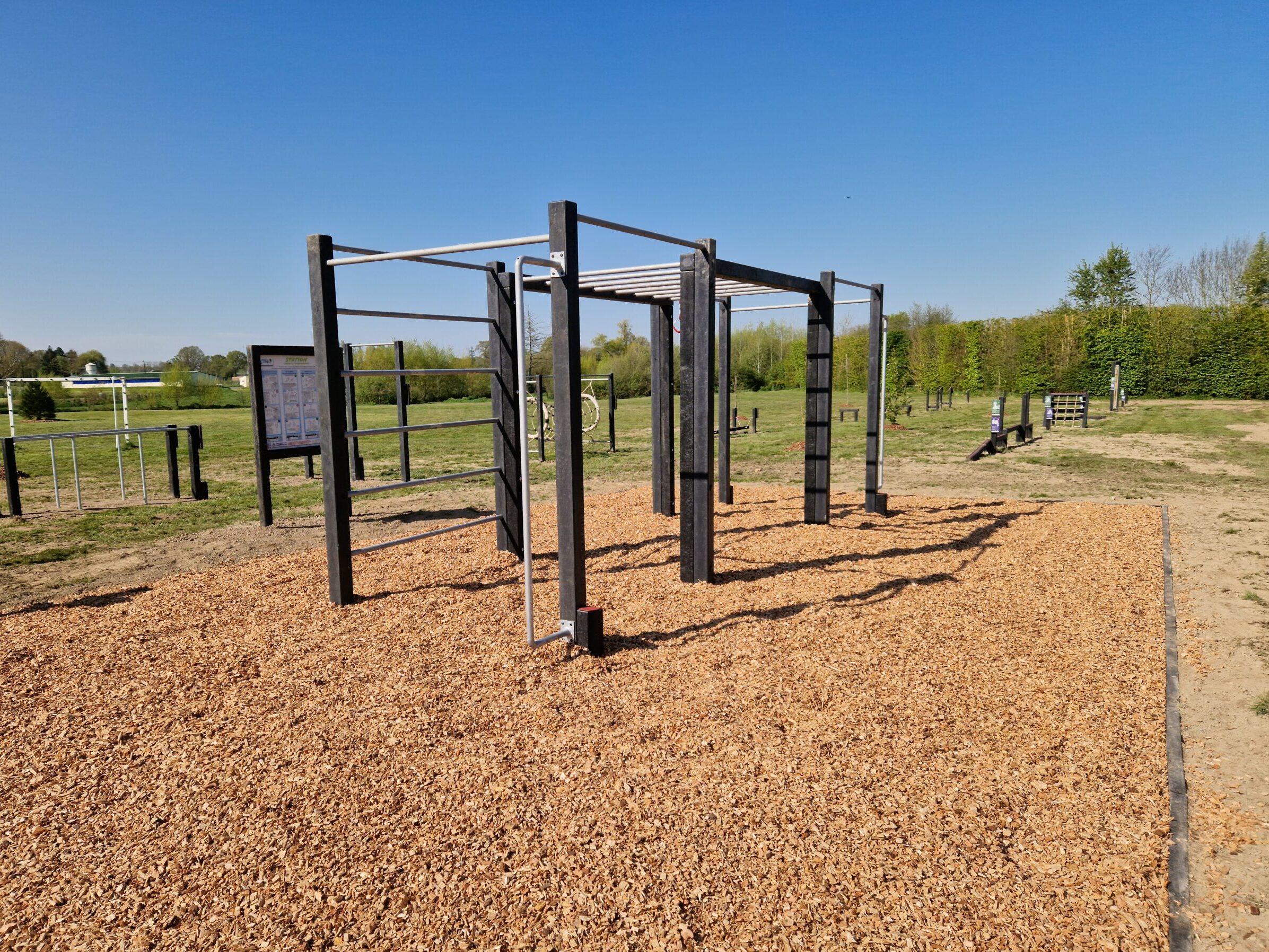 Cette image est une photographie d'une station de fitness en matières recyclées. Elle illustre l'ensemble des équipements sportifs de fitness que Nathis peut fournir et installer aux collectivités de Bretagne.