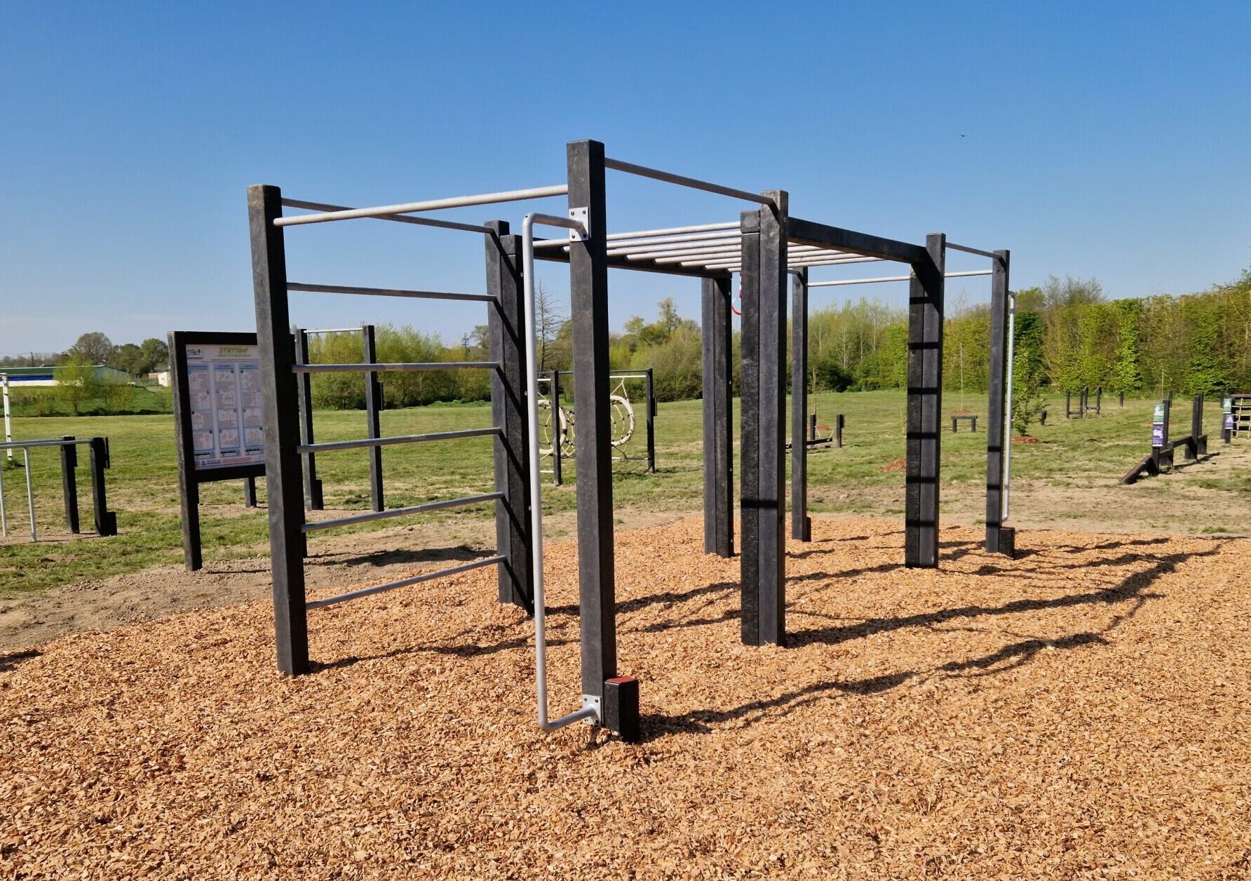 Cette image est une photographie d'une station de fitness en matières recyclées. Elle illustre l'ensemble des équipements sportifs de fitness que Nathis peut fournir et installer aux collectivités de Bretagne.