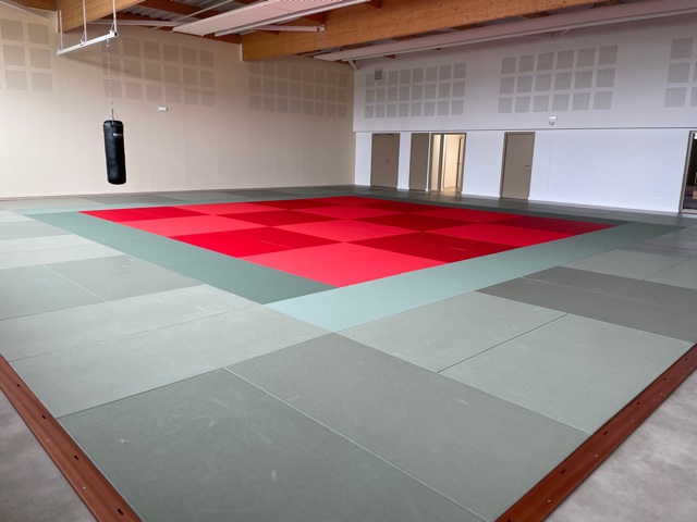 Cette image est une photographie d'un dojo, salle de boxe. Elle illustre l'ensemble des équipements pour sports de combat comme la boxe, la lutte, le judo et le karaté que Nathis fournit et installe pour les collectivités de Bretagne.